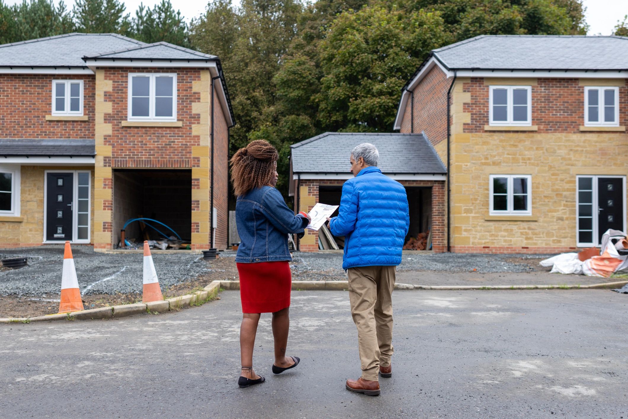 Real estate agent consulting with a client at a housing development